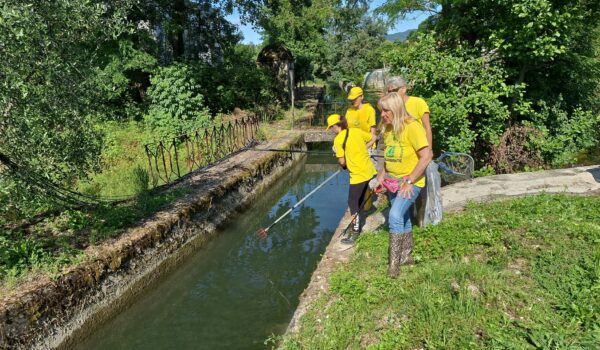 Attivisti al lavoro in un corso d'acqua per la pulizia dei fiumi e la cura del territorio.