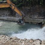 Mezzi al lavoro sul torrente Carrione a Carrara
